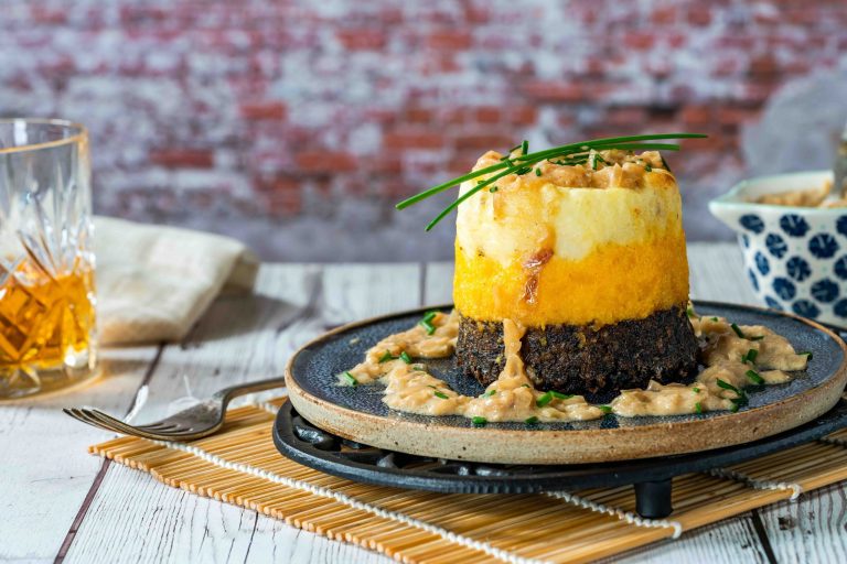 Haggis, neeps and tatties stack (haggis with turnips and potatoes) with whisky sauce - traditional Scottish dish for Burns Night