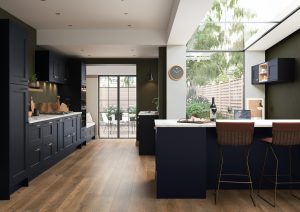 The Fiorenza Shaker Kitchen door in Slate Blue is showcased in this kitchen design, showing the doors in a kitchen design created by The Kitchen Depot. The kitchen Idecorated with modern and traditional twists, white wall and potted plants.