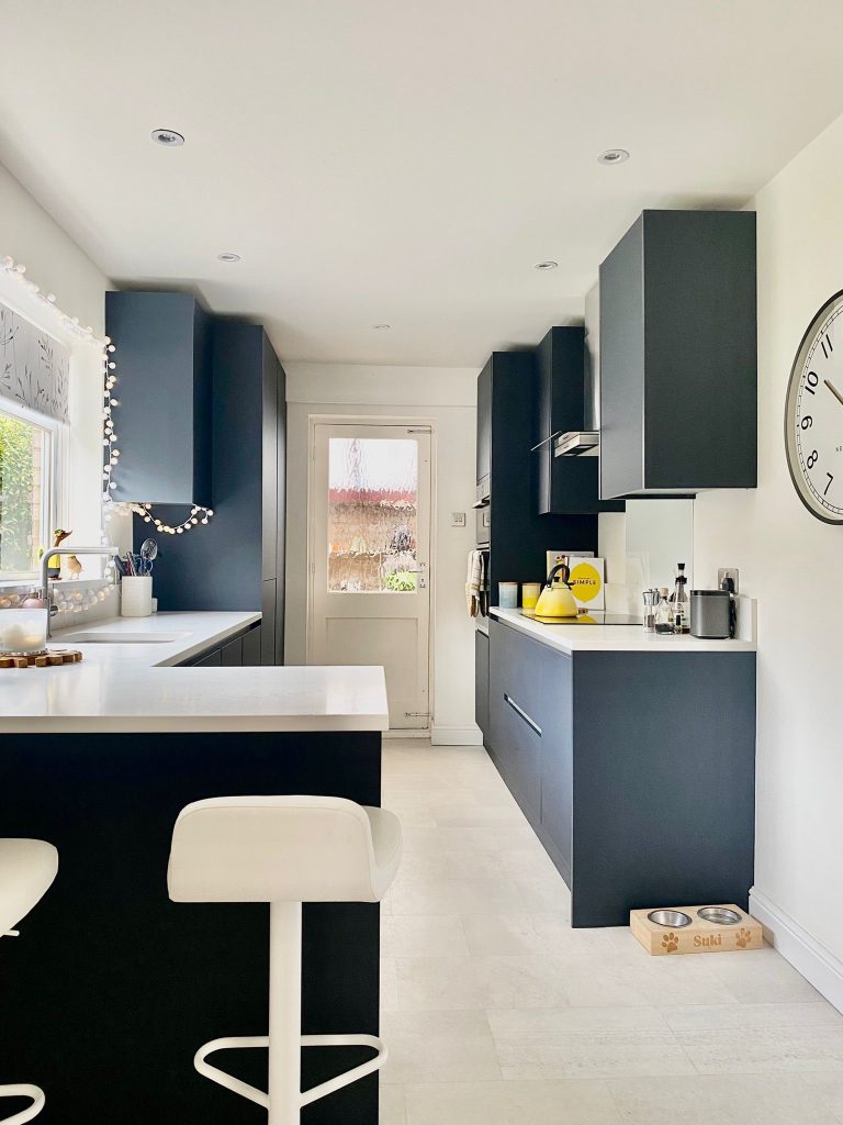 New modern galley kitchen with breakfast bar seating. Handleless Indigo Blue doors and Carrara Quartz work surfaces.