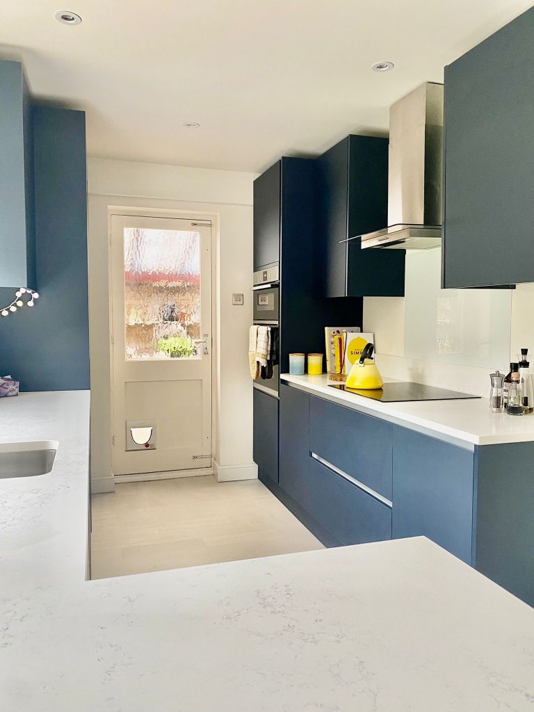 galley kitchen Handleless Indigo Blue doors and Carrara Quartz work surfaces.
