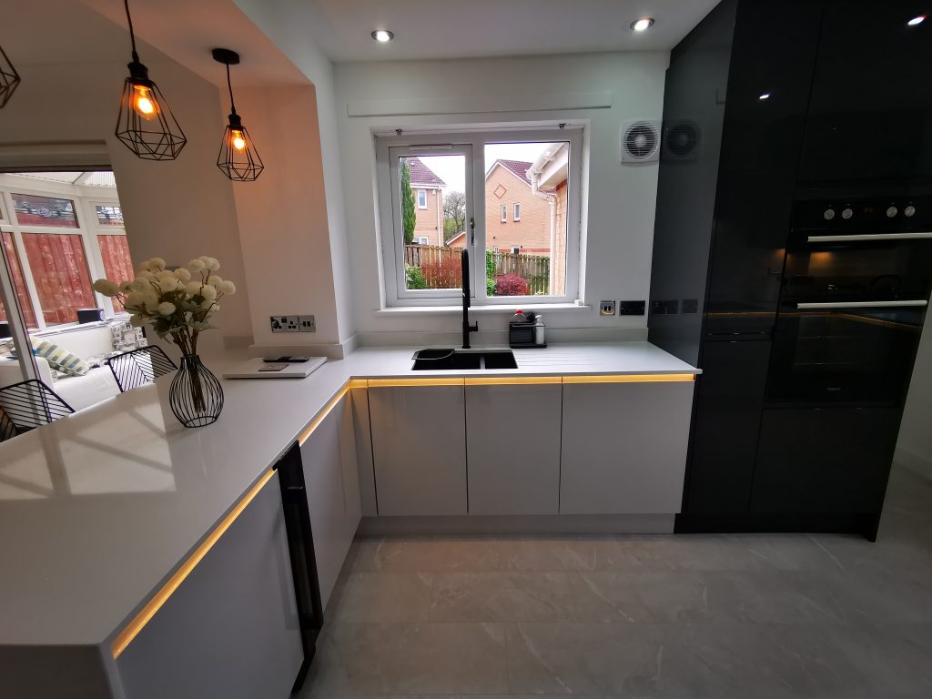 The Duncan Family's Light Grey & Graphite L-shaped kitchen with unique lighting by The Kitchen Depot
