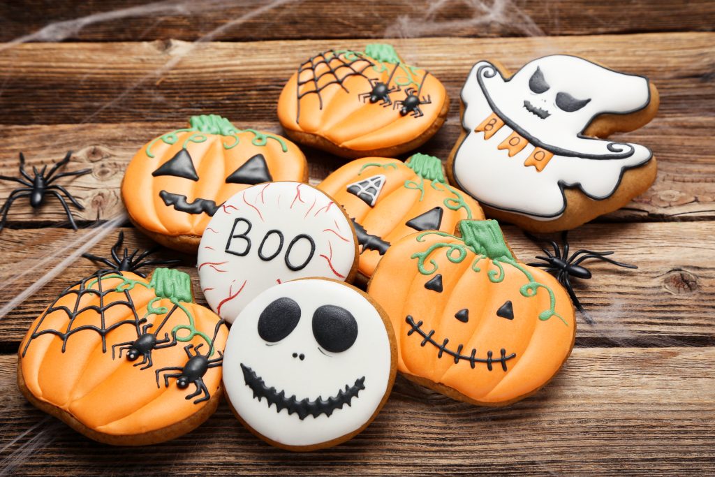 Halloween baking gingerbread biscuits with spiders, pumpkins and skulls