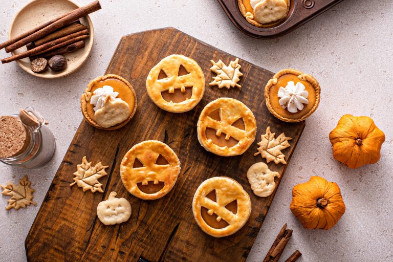 Halloween baking pumpkin pies with carved jack-o-latern