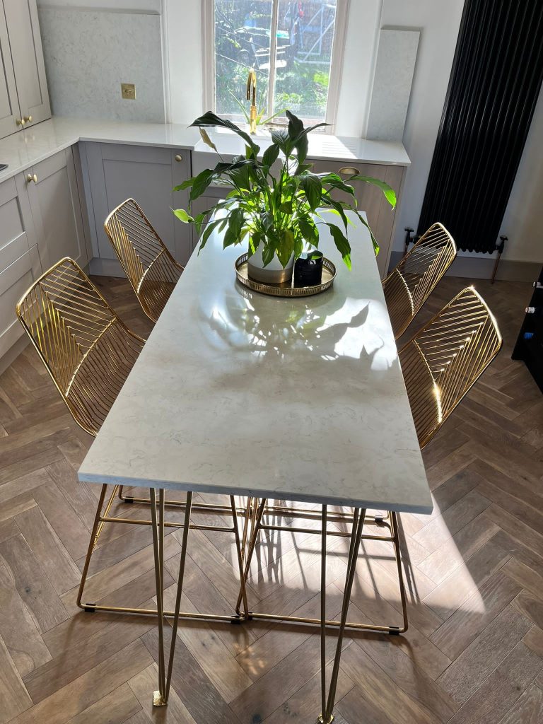 Cosentino Silestone Lusso worktops with ding table and gold chairs