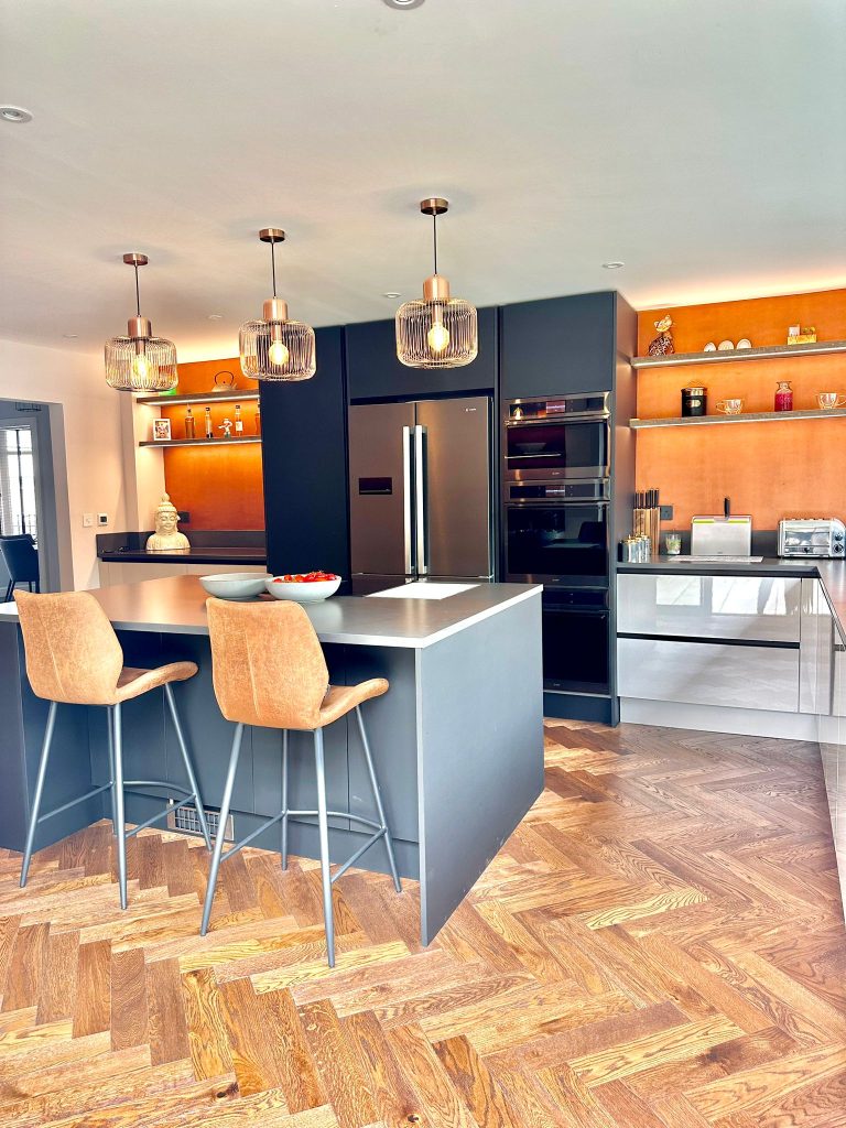 LINEA Matte Black & Cashmere Gloss Kitchen with orange chairs and walls