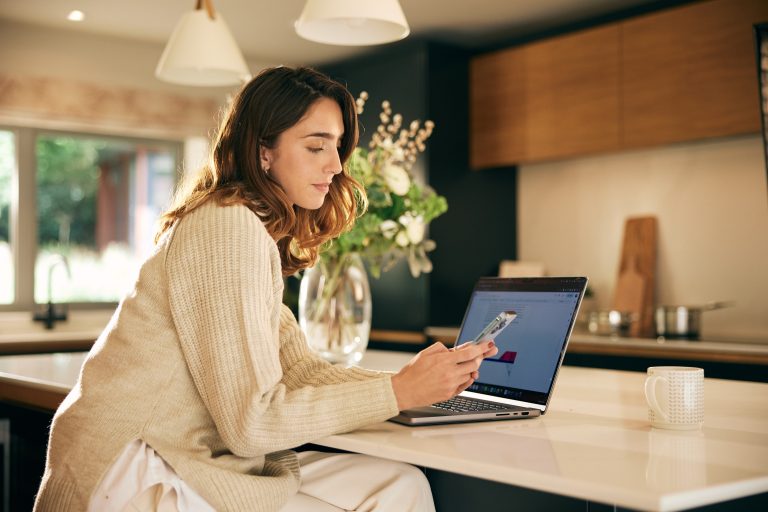 Zuma sound and light system in kitchen with woman using the app | The Kitchen Depot