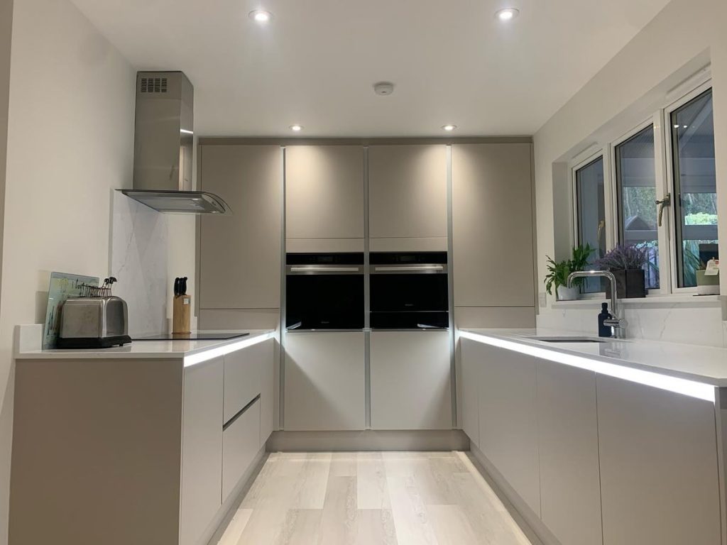 McQuat's Handleless Matte Cashmere Kitchen with silver rails and under worktop lighting